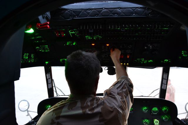 Český příslušník technické směny provádějící přípravu před letem s NVG uvnitř pilotní kabiny