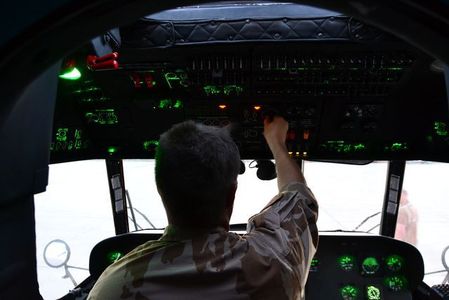 Český příslušník technické směny provádějící přípravu před letem s NVG uvnitř pilotní kabiny