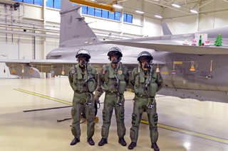 Trojice pilotů před dárky od dětí z českých škol, které jsou navěšené na letounu