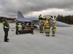 Estonští hasiči a záchranáři se u letounu JAS-39C Gripen připravují k vyproštění pilota