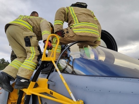 Estonští hasiči a záchranáři se u letounu JAS-39C Gripen připravují k vyproštění pilota