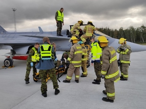 Estonští hasiči a záchranáři se u letounu JAS-39C Gripen připravují k vyproštění pilota