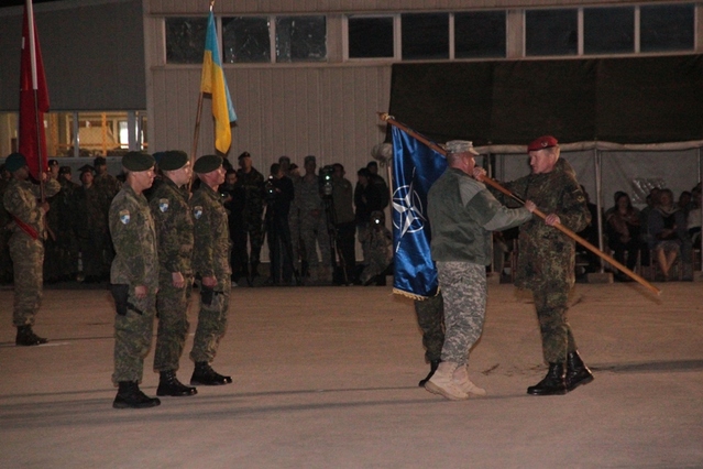 Symbolické předání vlajky NATO do rukou plukovníka Neumana velitelem KFOR