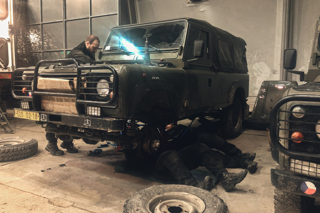 Mechanici během výměny spojky u vozidla landrover.