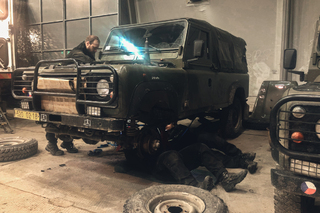 Mechanici během výměny spojky u vozidla landrover.