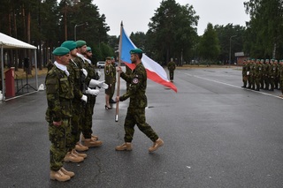 Kapitán Kurfiřt symbolicky předává českou vlajku jednotce
