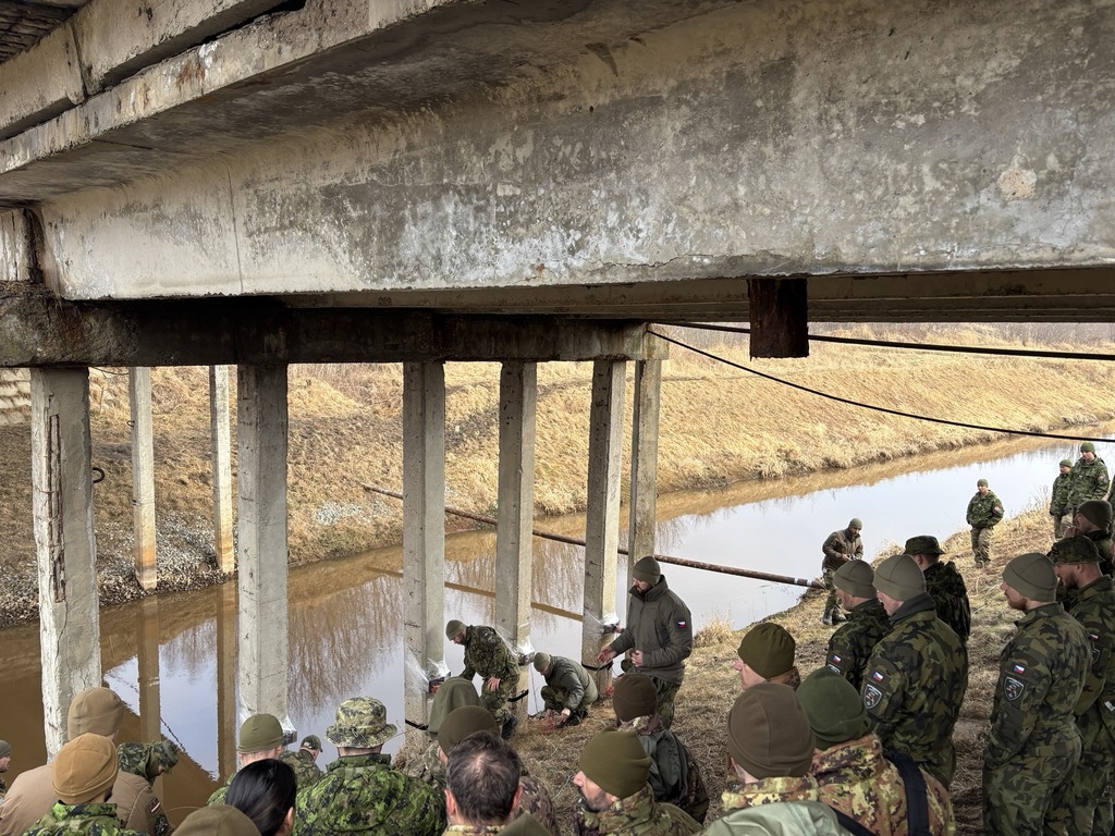 Velitel ženijní čety vysvětluje postup při přípravě mostu k ničení.