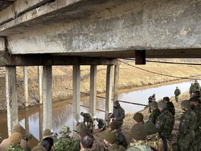 Velitel ženijní čety vysvětluje postup při přípravě mostu k ničení.