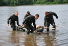 Improvised transport of "injured" colleague across a pond