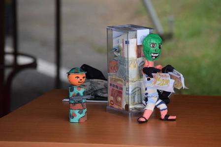 Výtvory zaslané žáky chrání kasičku v průběhu charitativní sbírky