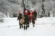 Družina Santa Clause blížící se zasněženou krajinou k jedné ze škol v horách nad Podujevem.
